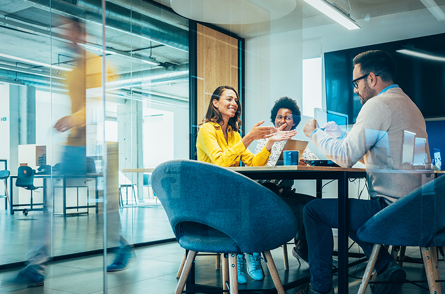 3 People sitting at a table and discussing something in an office space